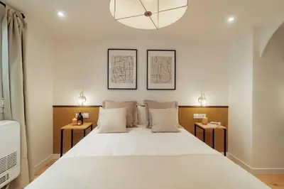 a bedroom with a large white bed with two tables at Casa Goya in Barcelona
