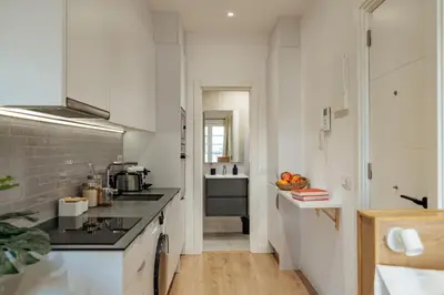 a kitchen with white cabinets and a counter top at Casa Laietana in Barcelona