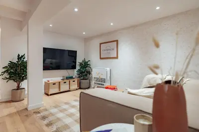 a living room with a couch and a flat screen tv at Casa Lennon in Barcelona