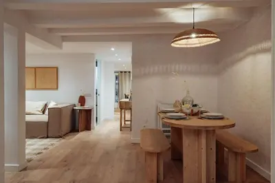 a kitchen and living room with a table and a couch at Casa Lennon in Barcelona
