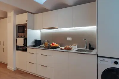 a kitchen with white cabinets and a bowl of fruit on the counter at Casa Lennon in Barcelona