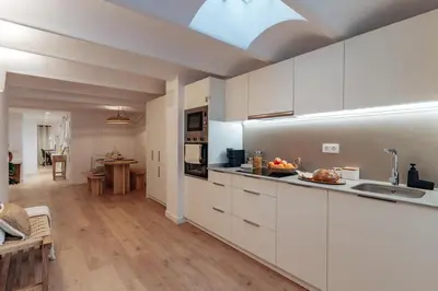a large kitchen with white cabinets and a table at Casa Lennon in Barcelona