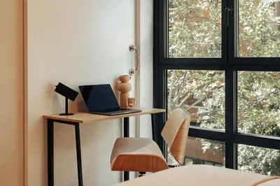 a bedroom with a desk with a laptop and a window at Casa Macaya in Barcelona