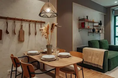 a dining room with a table and a green couch at Casa Macaya in Barcelona