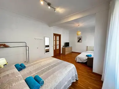 a bedroom with a large bed and a living room at Habitaciones acogedoras en Aragón in Barcelona