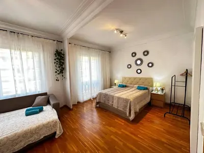 a bedroom with two beds and a couch in it at Habitaciones acogedoras en Aragón in Barcelona