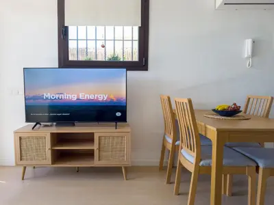 a living room with a television on a wooden table at Apartamento en la playa in Castelldefels