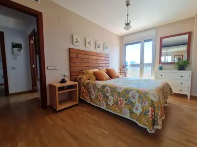a bedroom with a large bed with a wooden headboard at Pis molt cèntric amb vistes in Terrassa