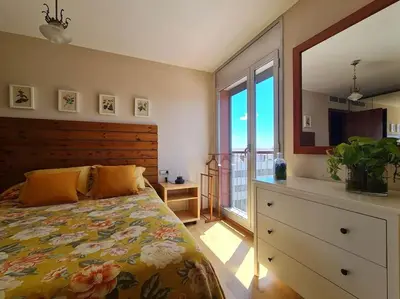 a bedroom with a bed and a dresser and a window at Pis molt cèntric amb vistes in Terrassa