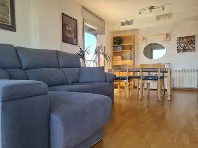 a living room with a blue couch and a table at Pis molt cèntric amb vistes in Terrassa