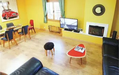 a living room with a couch and a table and a tv at Lovely Home In St Cebrià De Vallalta in Sant Cebrià de Vallalta