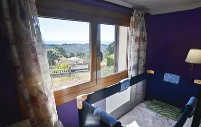 a bedroom with a bed and a large window at Lovely Home In St Cebrià De Vallalta in Sant Cebrià de Vallalta