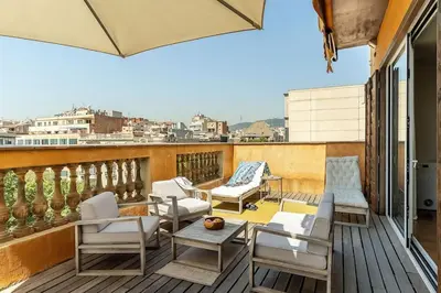 a balcony with white chairs and a table at Canela Homes BARCELONA ATIC in Barcelona