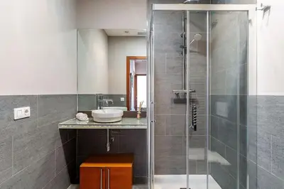 a bathroom with a glass shower and a sink at Canela Homes BARCELONA ATIC in Barcelona
