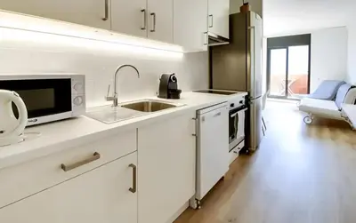 a white kitchen with a sink and a microwave at Urban Flats Park Guell in Barcelona