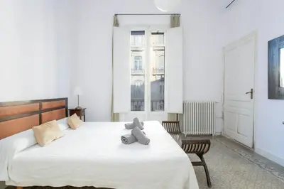 a teddy bear sitting on a bed in a bedroom at Canela Homes BARCELONA CASA SERRA in Barcelona