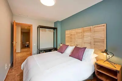 a bedroom with a large white bed with purple pillows at Canela Homes BARCELONA TETUAN in Barcelona