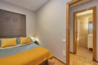 a bedroom with a bed with yellow pillows and a mirror at Canela Homes BARCELONA TETUAN in Barcelona