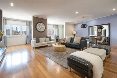 a living room filled with furniture and a clock on the wall at Canela Homes BARCELONA CENTRAL in Barcelona
