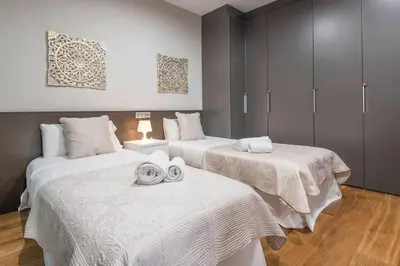 a room with three beds with white sheets on them at Canela Homes BARCELONA CENTRAL in Barcelona
