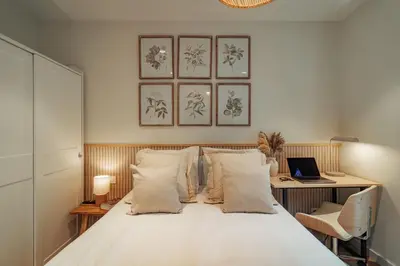 a bedroom with a bed and a desk with a laptop at Casa Marina in Barcelona