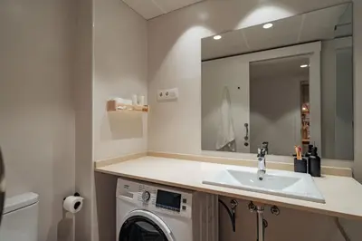 a bathroom with a sink and a washing machine at Casa Marina in Barcelona