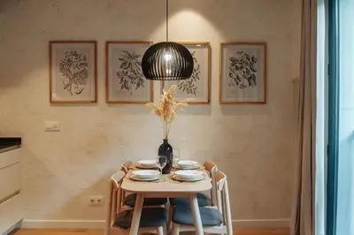 a table with chairs and a vase on it at Casa Seda in Barcelona
