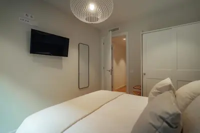 a bedroom with a bed and a tv on the wall at Casa Tila in Barcelona