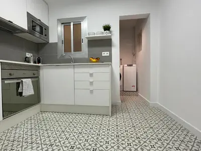 a kitchen with white cabinets and a tile floor at 15 min en metro a Sagrada Familia in Sant Adria de Besos