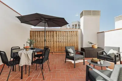 a patio with a table and chairs and an umbrella at Olivo - 1 bedroom and terrace in Eixample Esquerra in Barcelona