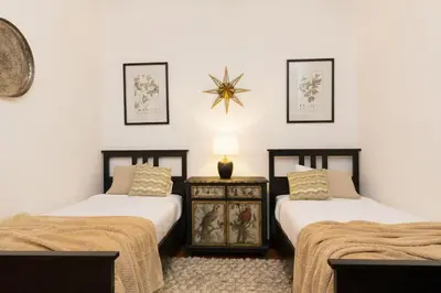 a bedroom with two beds and a table with a lamp at Canela Homes BARCELONA INDÚSTRIA in Barcelona