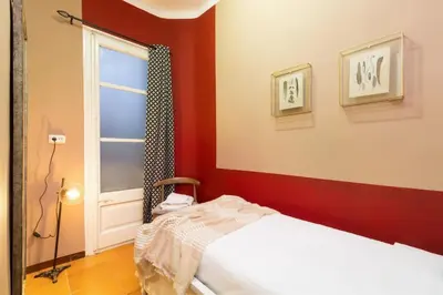 a red room with a bed and a window at Canela Homes BARCELONA INDÚSTRIA in Barcelona