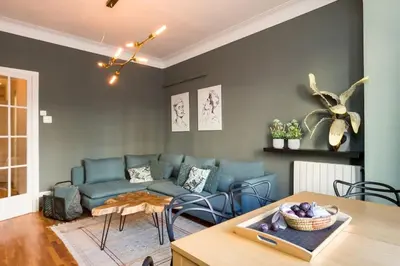 a living room with a blue couch and a table at Canela Homes BARCELONA INDÚSTRIA in Barcelona