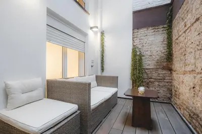 a balcony with wicker chairs and a table at Chic Poble Nou Loft Terrace & Close to The Beach in Barcelona