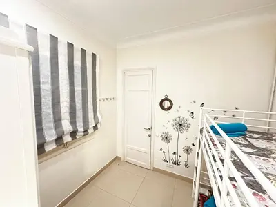a white bedroom with a bed and a window at Isabela rooms in Barcelona