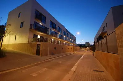 an empty street in front of a building at night at Resort Sitges Apartment in Sitges