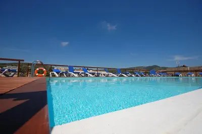 a swimming pool with chairs and a water slide at Resort Sitges Apartment in Sitges