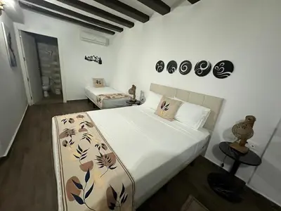 a bedroom with a large white bed with flowers on it at Vilador Barcelona Beach Hotel in Masnou