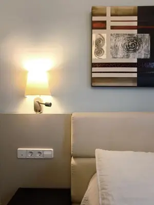 a lamp next to a bed in a room at Hotel Llar de Capitans in Masnou