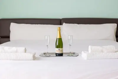 a bottle of champagne and two glasses on a bed at Hotel Llar de Capitans in Masnou