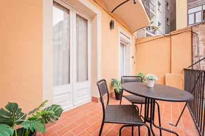 a patio with a table and chairs on a balcony at Sweett - Urgell Eixample in Barcelona