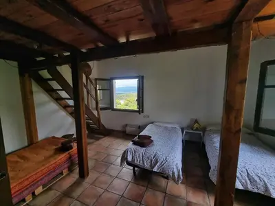 an attic room with two beds and a window at L'AMAGATALL DEL MONTNEGRE in Villalba Saserra