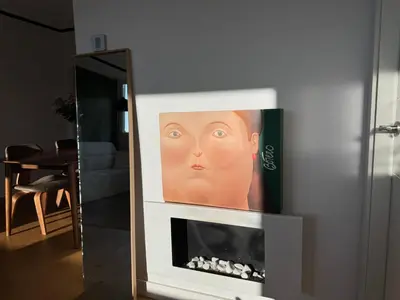 a painting of a face on a fireplace in a living room at Paseo de Gracia Residences in Barcelona