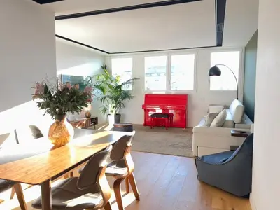 a living room with a table and a red piano at Paseo de Gracia Residences in Barcelona