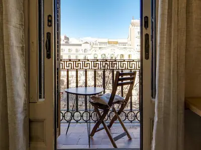 a chair sitting on a balcony with a table at Casa modernista en Paseo de Gracia in Barcelona