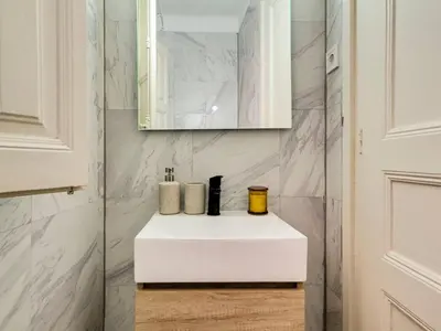 a bathroom with a white sink and a mirror at Casa modernista en Paseo de Gracia in Barcelona