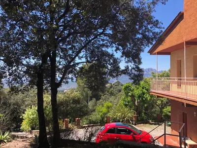 a red car parked in front of a house at villa 7 personnes 45 mn Barcelone vue sur Montserrat in Vacarisas