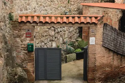 an entrance to a brick building with a gate at Habitación Cavall Bernat en Casa Camí de les Aigües Monistrol de Montserrat in Monistrol