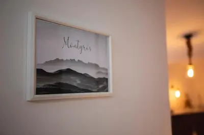 a picture hanging on a wall with a picture of mountains at Habitación Montgros en Casa Camí de les Aigües Monistrol de Montserrat in Monistrol