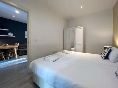 a bedroom with a large white bed and a dining room at Stay U-nique Apartments Rossello in Barcelona
